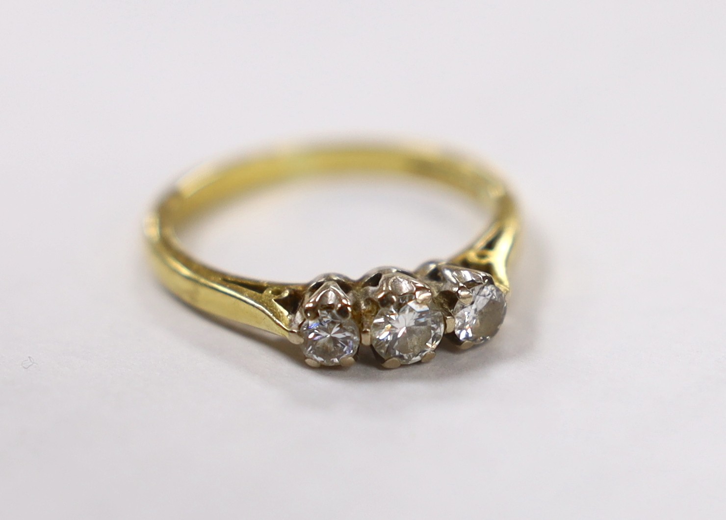 A modern 18ct white gold and three stone diamond set ring, size P, gross weight 3.9 grams.